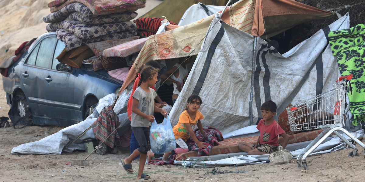 Plant yn Gaza yn eistedd wrth ymyl pabell, ar ôl i Hamas gytuno i ryddhau gwystlon