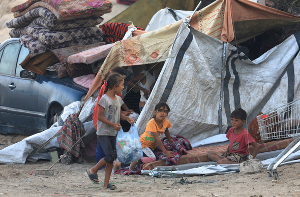 Plant yn Gaza yn eistedd wrth ymyl pabell, ar ôl i Hamas gytuno i ryddhau gwystlon