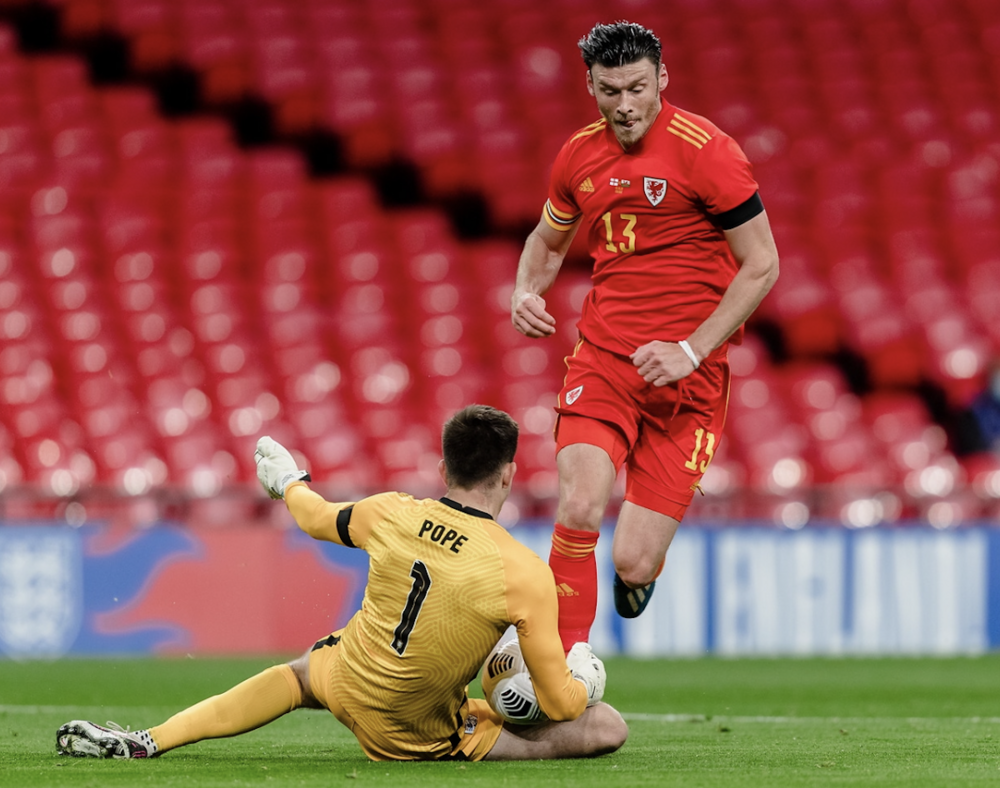 Kieffer Moore yn ceisio rhedeg heibio Nick Pope