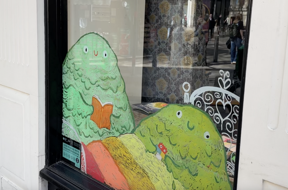 Y blobs yn llenwi ffenest siop Waterstones yng Nghaerdydd