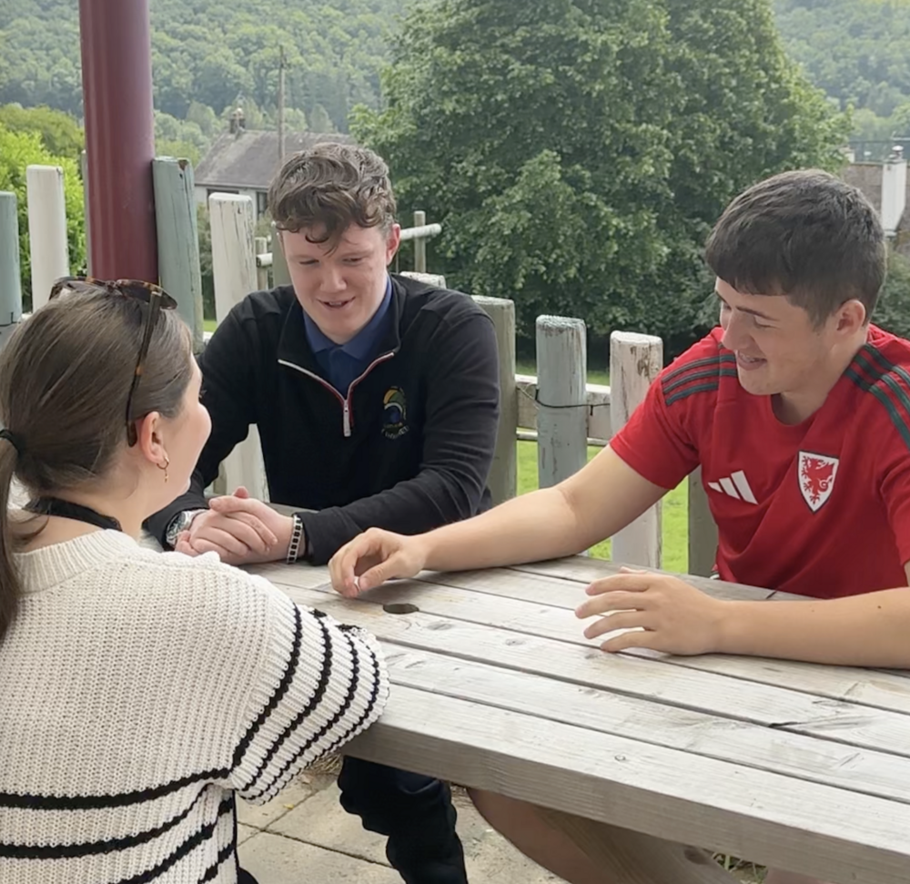 Bedwyr (crys Cymru), Iestyn (siwmper du) ac Elisa yn sgwrsio