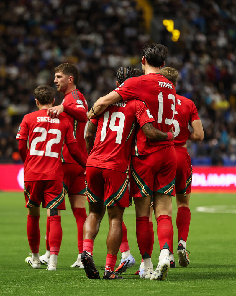 Kieffer Moore yn cofleidio Sorba Thomas ar ôl i'r ymosodwr sgorio ei 15fed gôl dros ei wlad