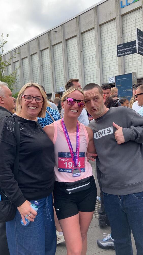 Carly gyda'i rheini ar ôl cwblhau hanner marathon Abertawe. (Llun: Carly Evans)